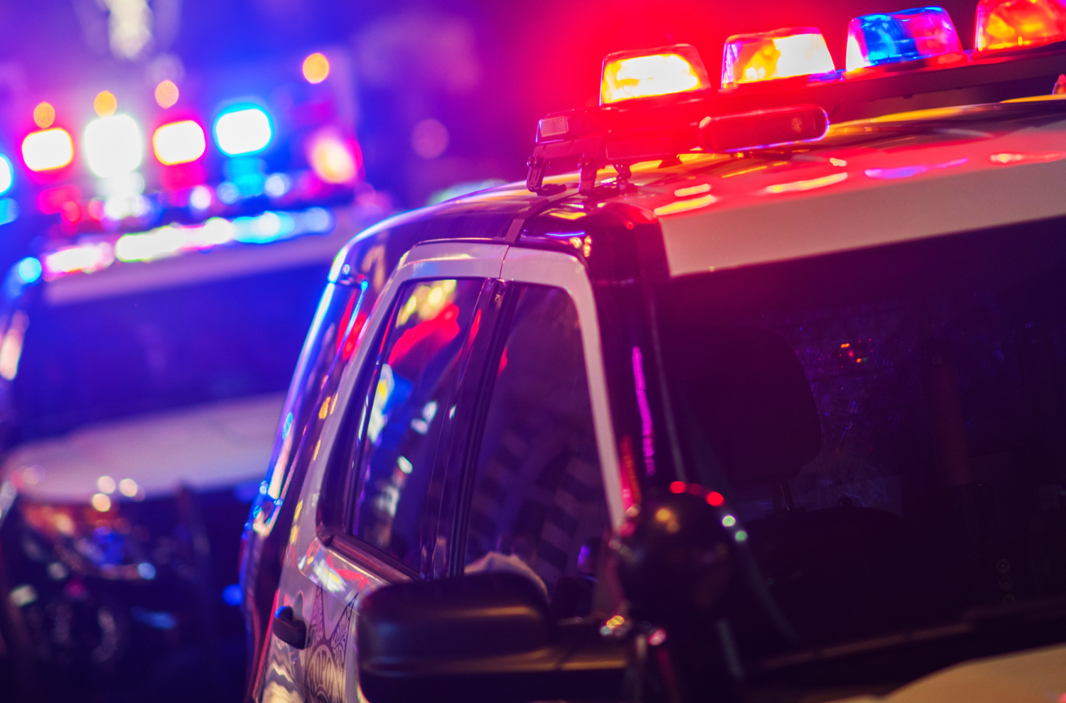 Police cruisers parked parallel with lights flashing