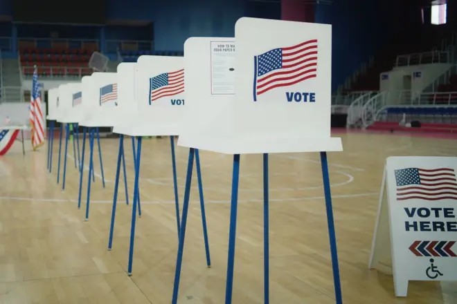 Row of voting booths set up inside school gymnasium