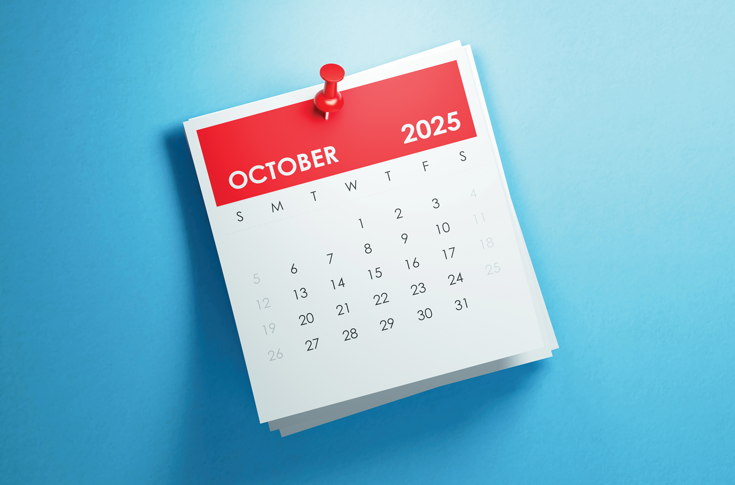 October 2025 calendar sitting on top of a blue table