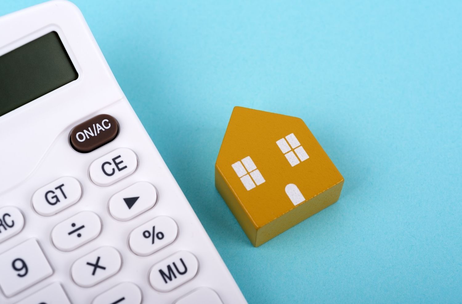 House wooden block on table next to calculator
