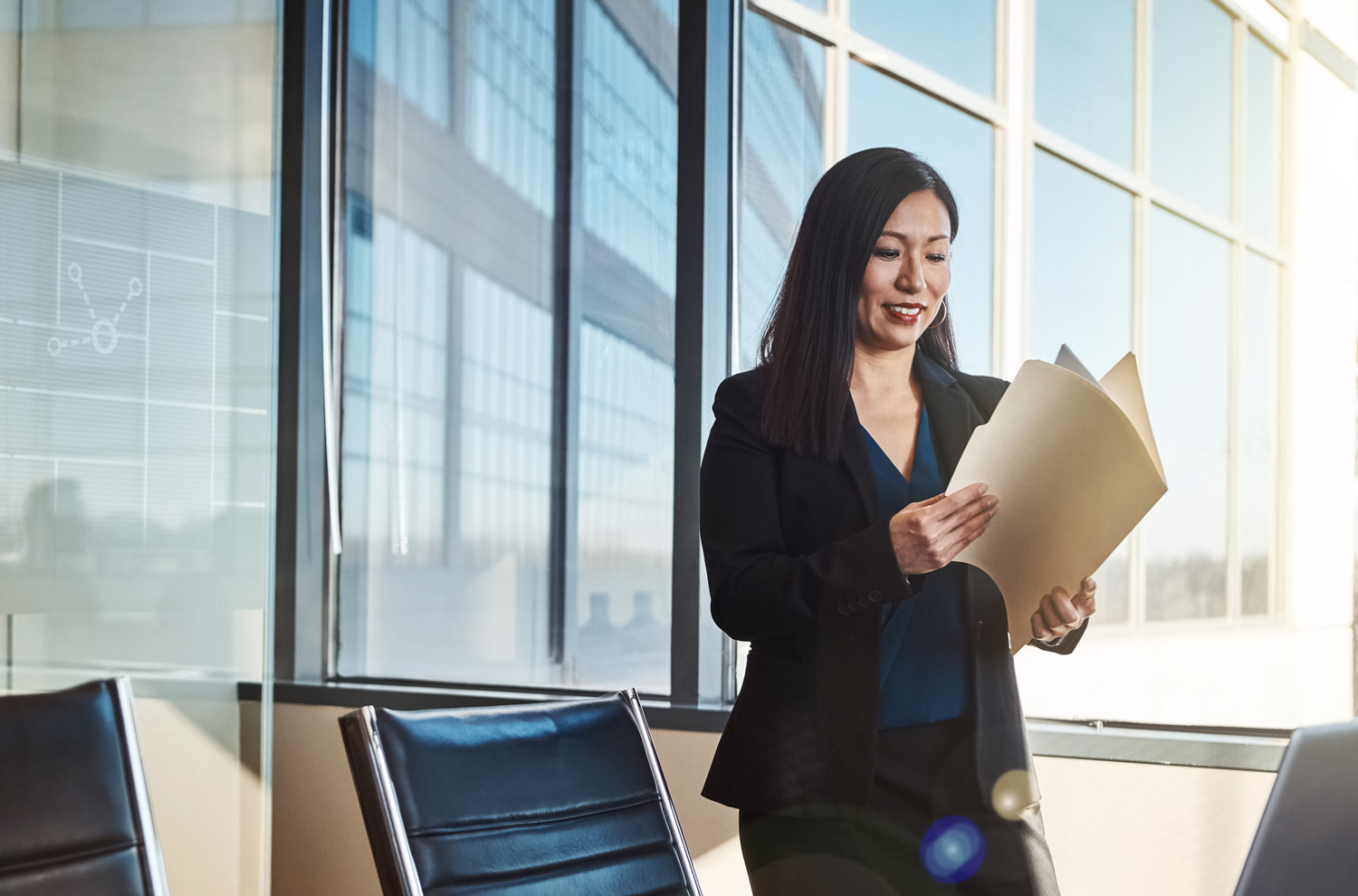Businesswoman looking at folder with paperwork