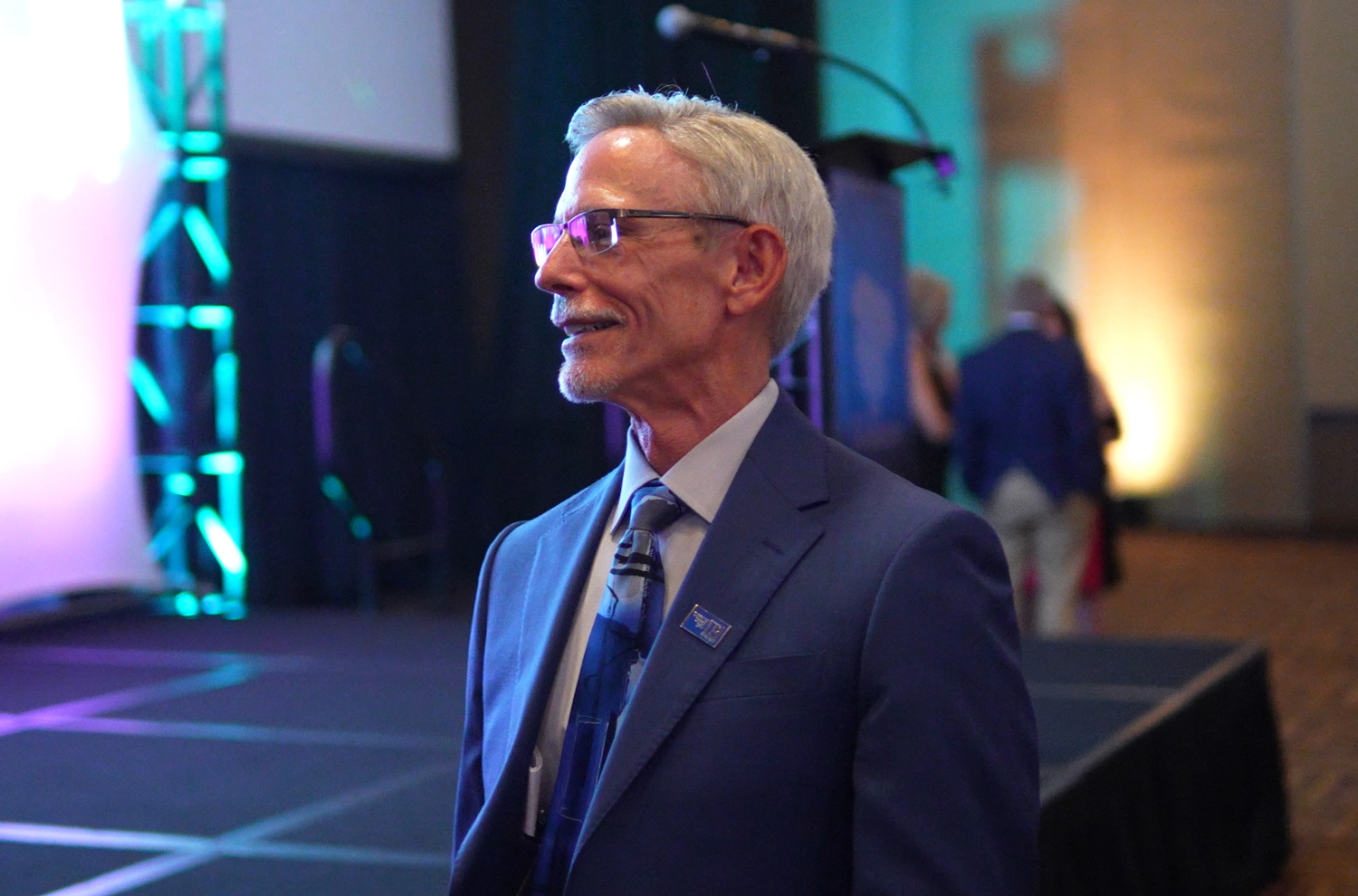 Chris DeVincentis attending convention with keynote speaker stage in background