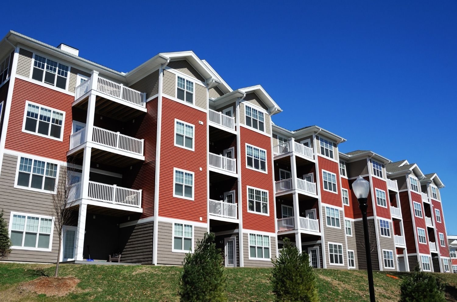 Exterior view of red and brown condominium building on a sunny day
