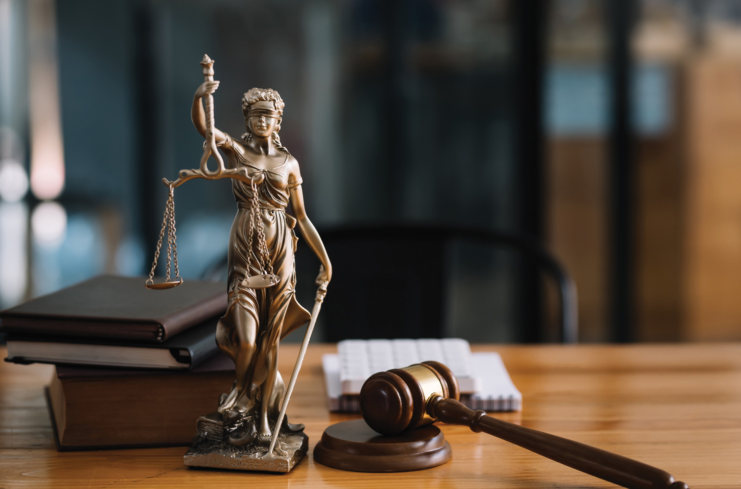 Lady justice statue on desk with books and gavel