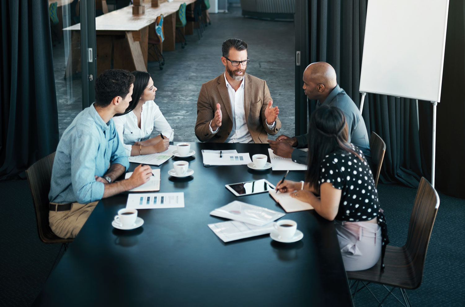 Manager leading a team meeting at table
